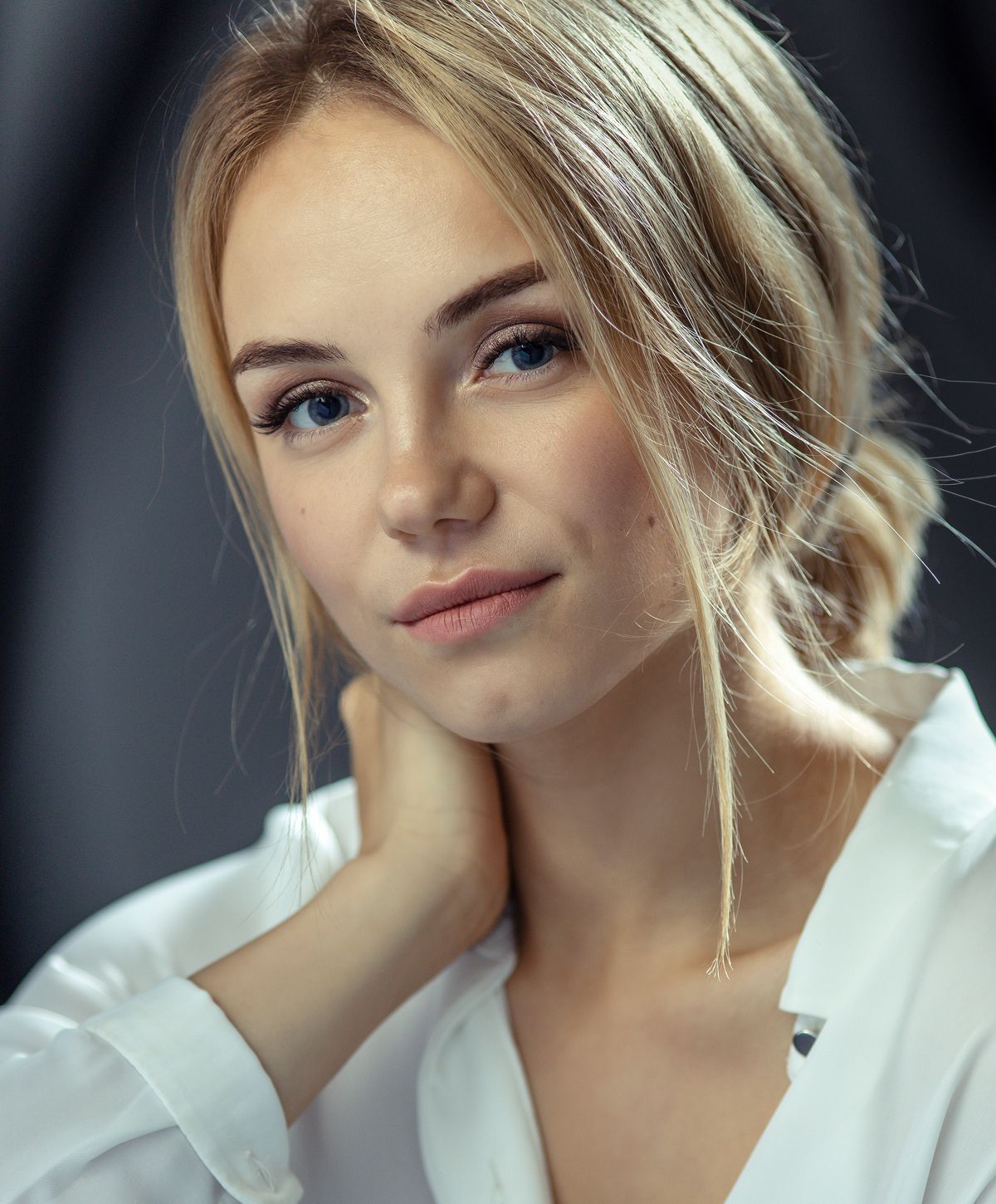 Young woman with blonde hair and soft expression.