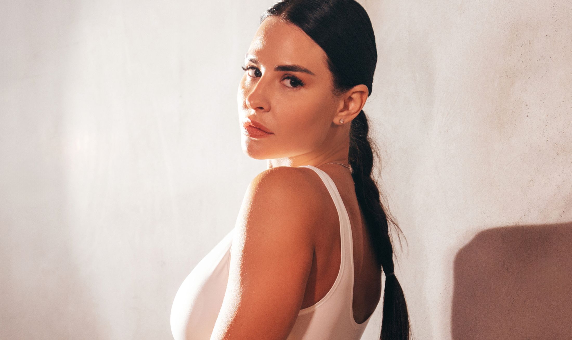Woman in white top, looking over shoulder.