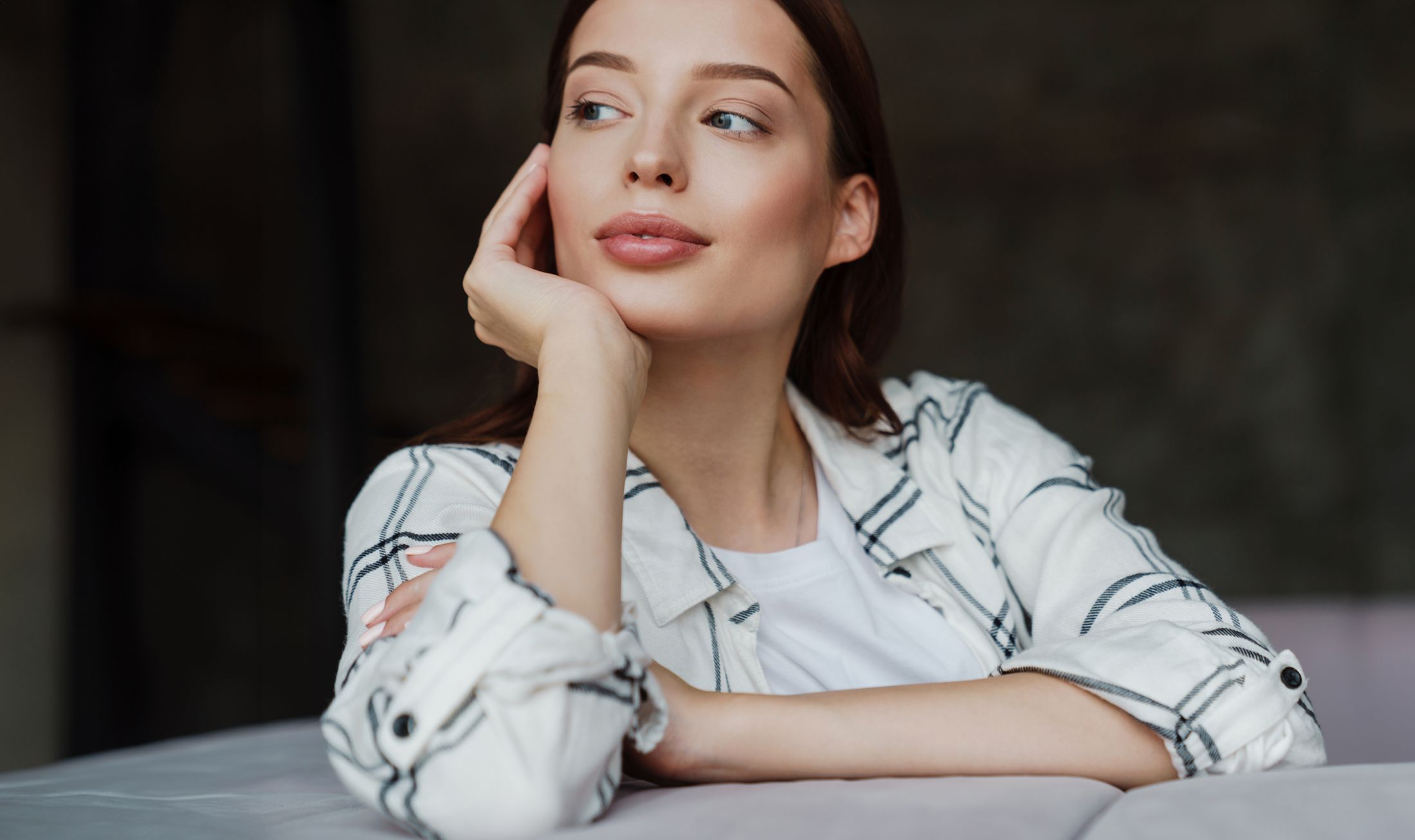 Thoughtful woman resting her chin on hand.